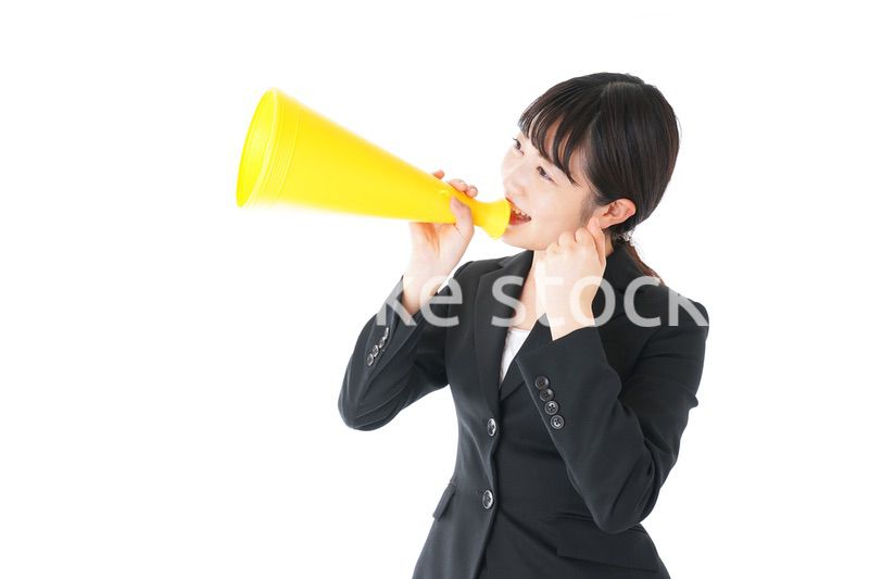 メガフォンで応援をするスーツを着たビジネスウーマン