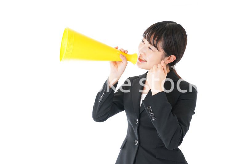 メガフォンで応援をするスーツを着たビジネスウーマン