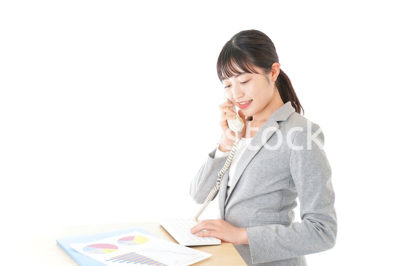 オフィスで固定電話を使う若いビジネスウーマン