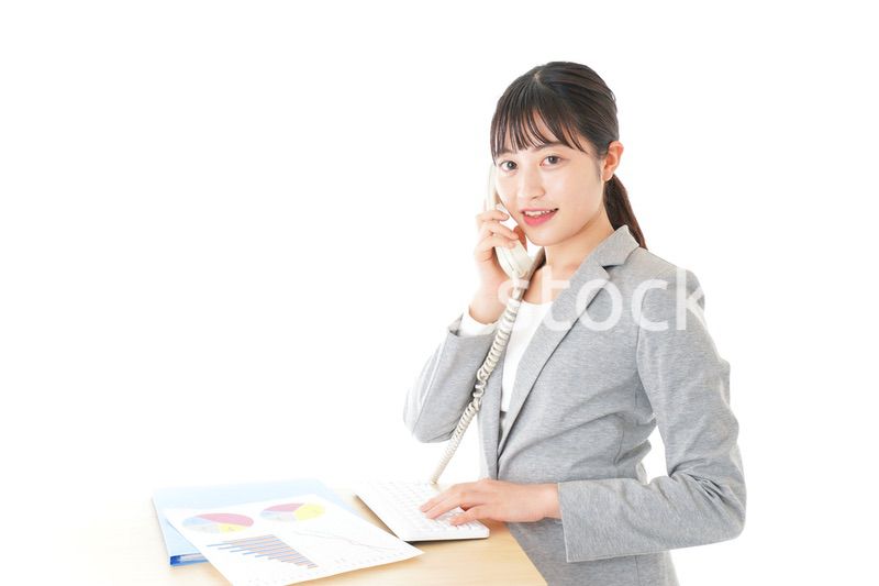 オフィスで固定電話を使う若いビジネスウーマン