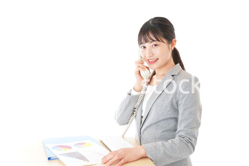 オフィスで固定電話を使う若いビジネスウーマン