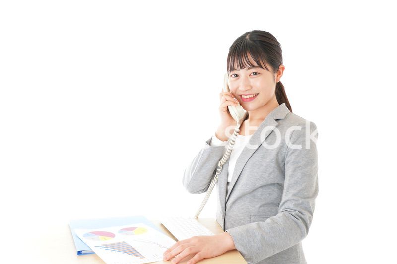 オフィスで固定電話を使う若いビジネスウーマン