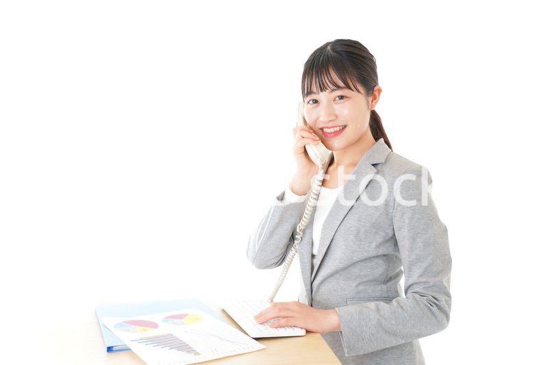 オフィスで固定電話を使う若いビジネスウーマン