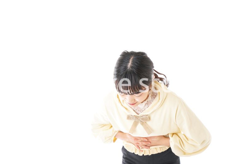 腹痛に苦しむ若い女性