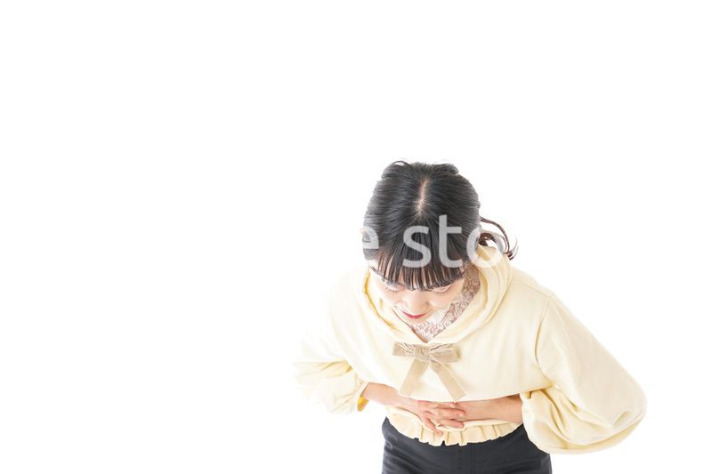 腹痛に苦しむ若い女性