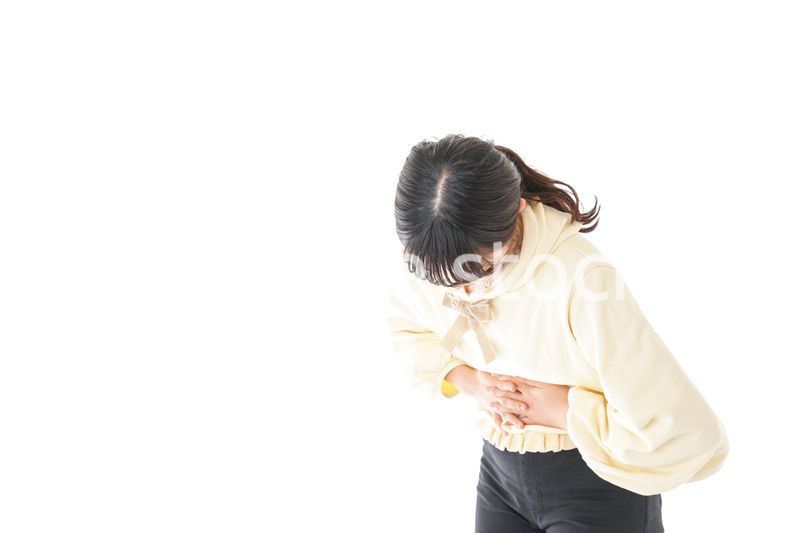 腹痛に苦しむ若い女性