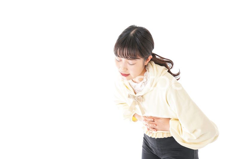 腹痛に苦しむ若い女性