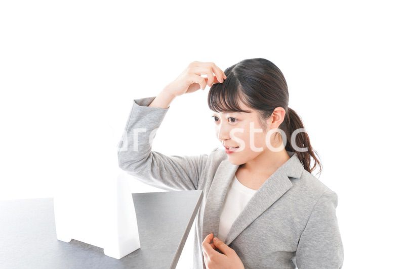 ヘアスタイルを整えるビジネスウーマン