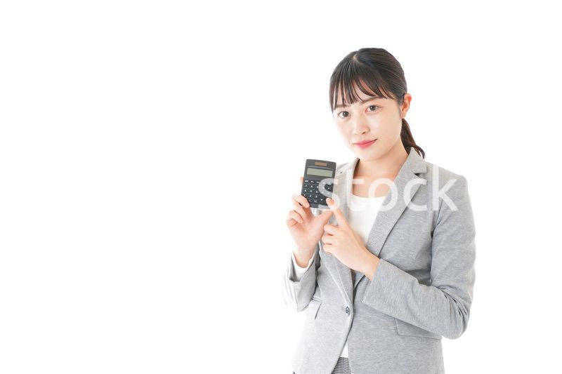 電卓で計算をする若いキャリアウーマン