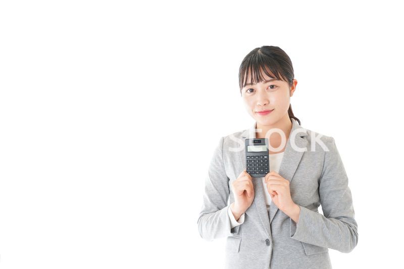 電卓で計算をする若いキャリアウーマン