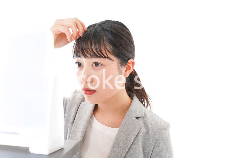 ヘアスタイルを整えるビジネスウーマン