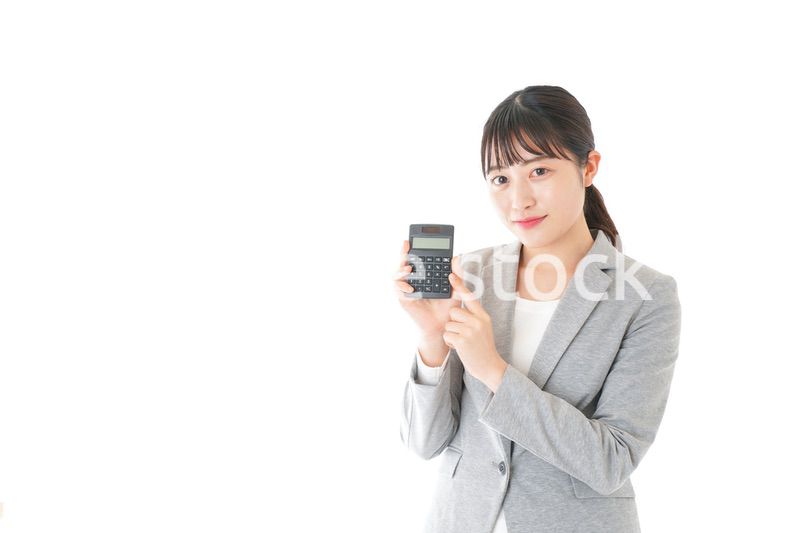 電卓で計算をする若いキャリアウーマン