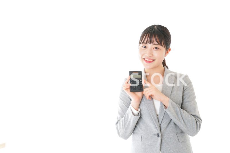 電卓で計算をする若いキャリアウーマン