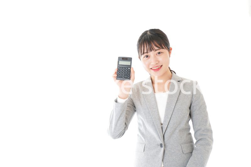 電卓で計算をする若いキャリアウーマン