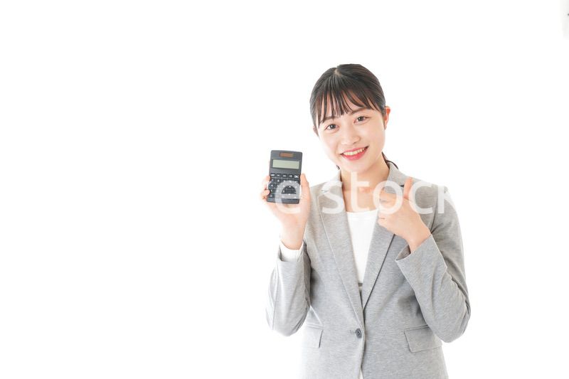 電卓で計算をする若いキャリアウーマン