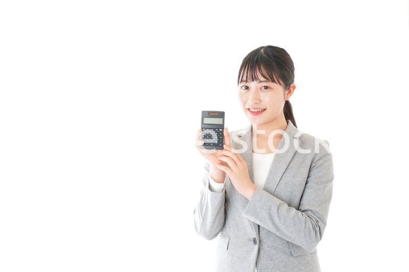 電卓で計算をする若いキャリアウーマン