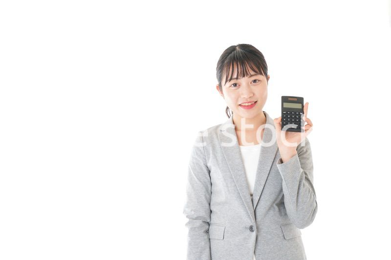 電卓で計算をする若いキャリアウーマン