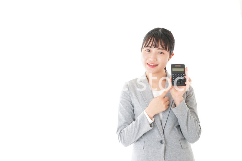 電卓で計算をする若いキャリアウーマン