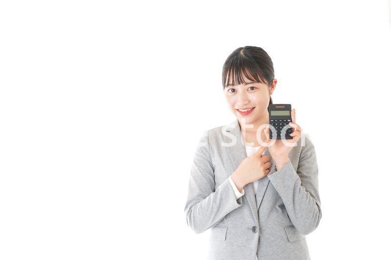 電卓で計算をする若いキャリアウーマン