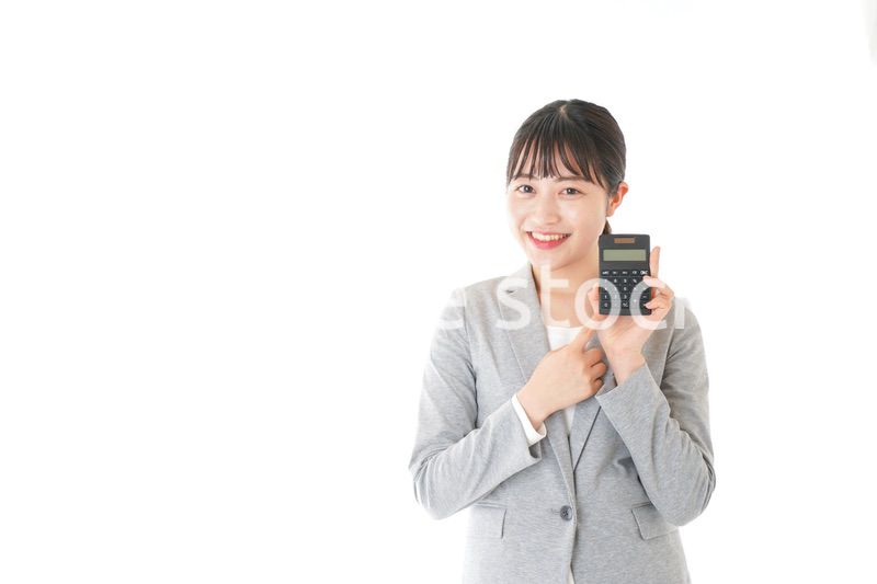 電卓で計算をする若いキャリアウーマン