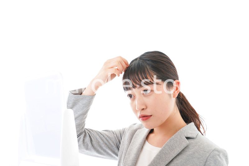 ヘアスタイルを整えるビジネスウーマン