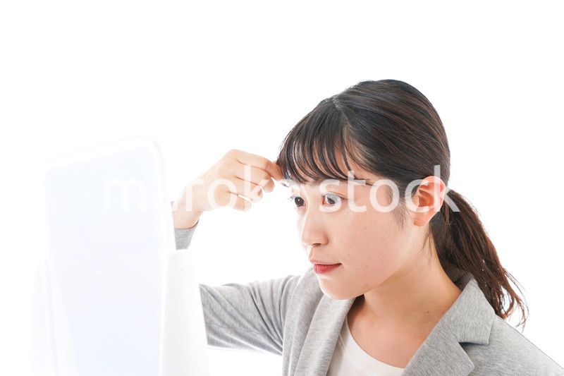 ヘアスタイルを整えるビジネスウーマン