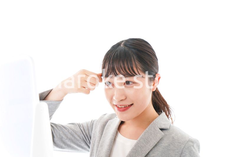 ヘアスタイルを整えるビジネスウーマン