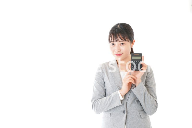 電卓で計算をする若いキャリアウーマン