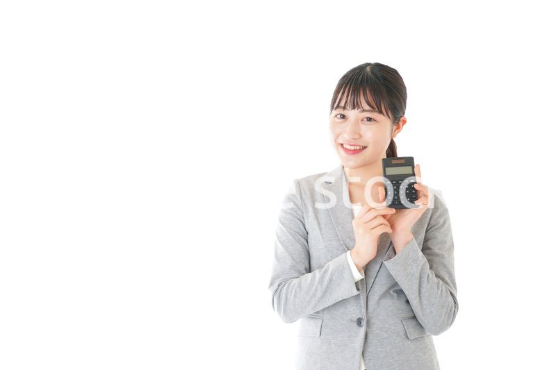 電卓で計算をする若いキャリアウーマン