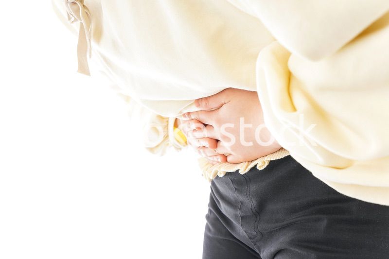 腹痛に苦しむ若い女性