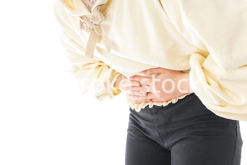 腹痛に苦しむ若い女性