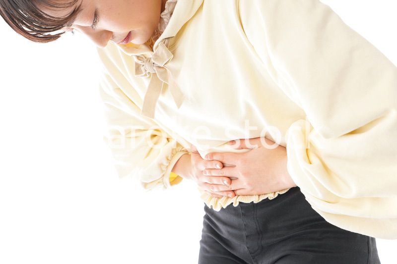 腹痛に苦しむ若い女性