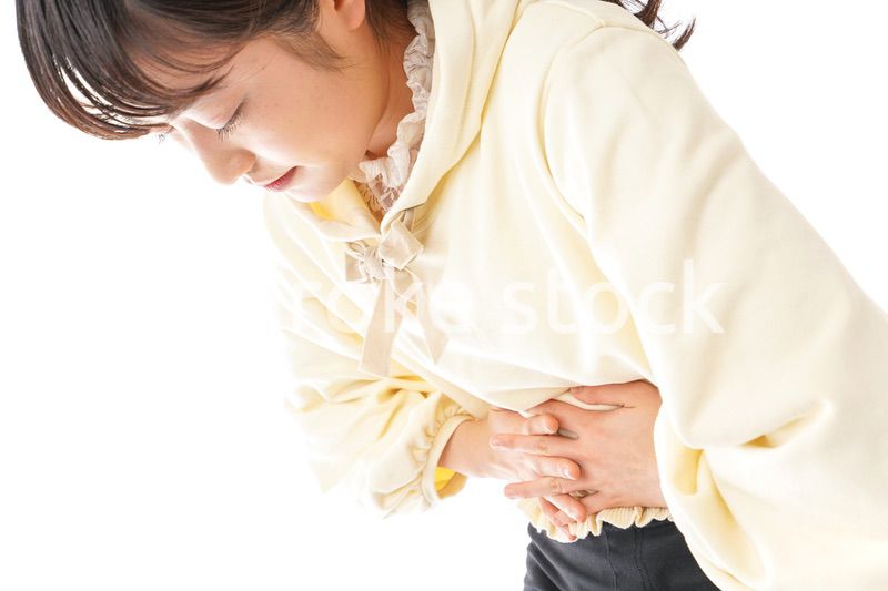 腹痛に苦しむ若い女性