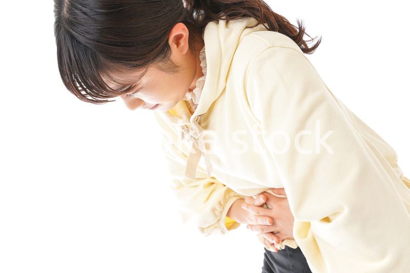腹痛に苦しむ若い女性