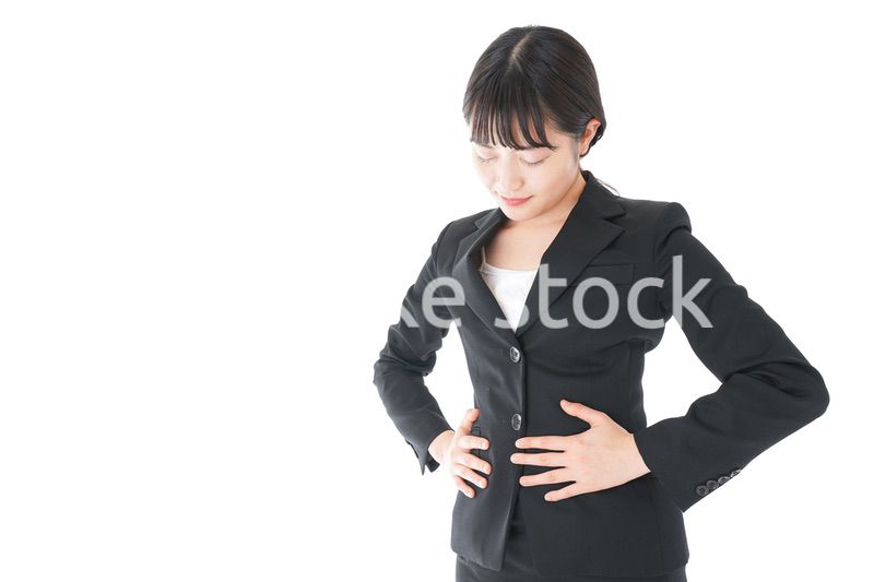 腹痛に苦しむ若いビジネスウーマン
