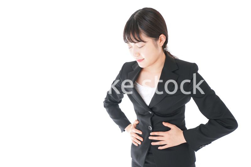 腹痛に苦しむ若いビジネスウーマン