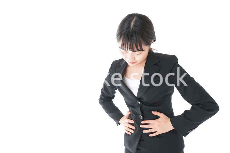 腹痛に苦しむ若いビジネスウーマン
