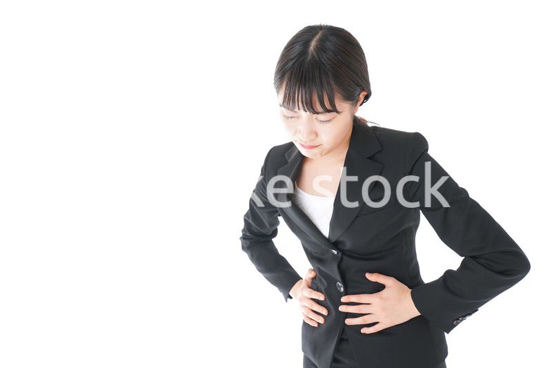 腹痛に苦しむ若いビジネスウーマン