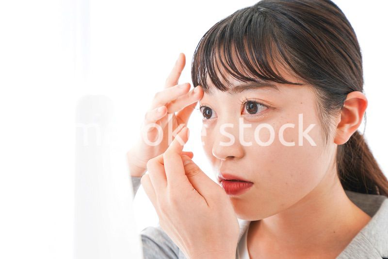 コンタクトレンズを入れるビジネスウーマン