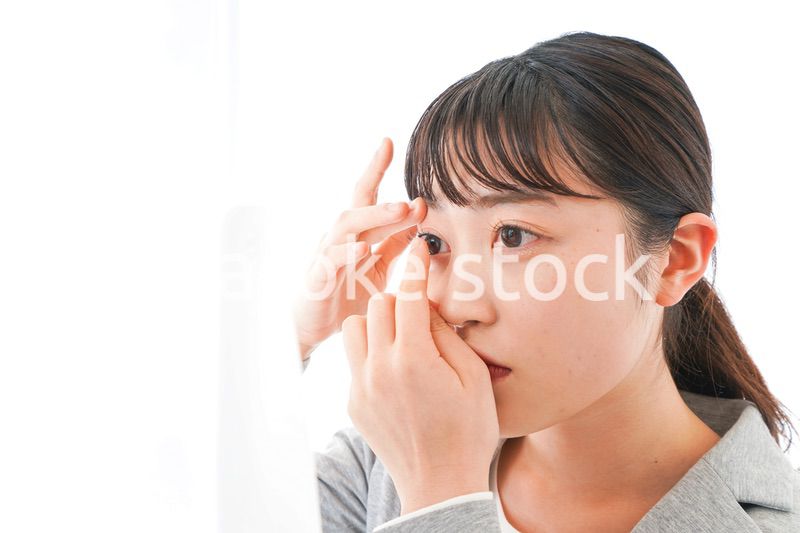 コンタクトレンズを入れるビジネスウーマン