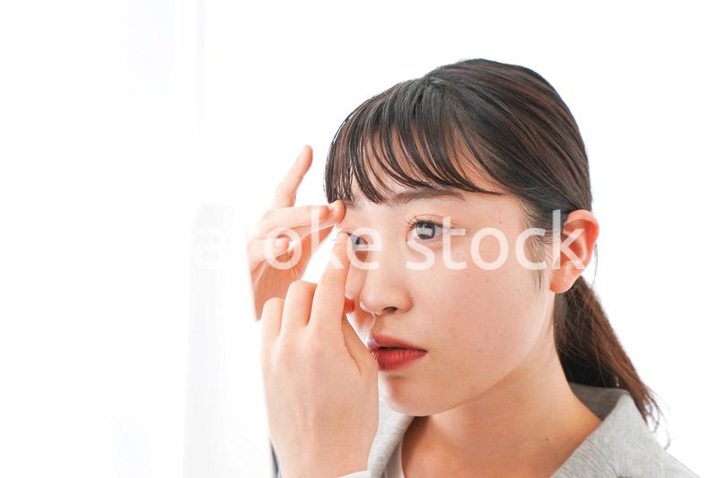 コンタクトレンズを入れるビジネスウーマン