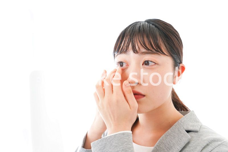 コンタクトレンズを入れるビジネスウーマン
