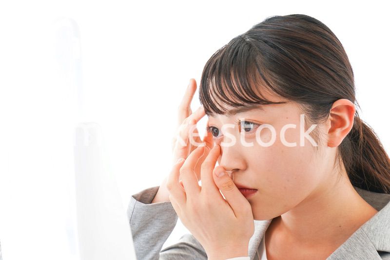 コンタクトレンズを入れるビジネスウーマン