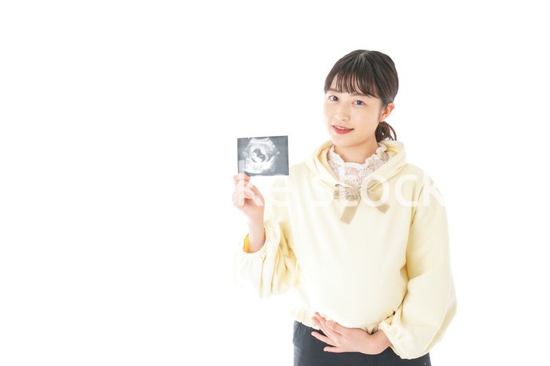 エコー画像を持つ若い妊婦の女性