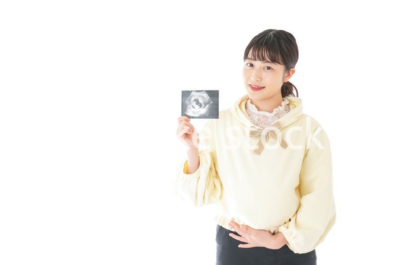 エコー画像を持つ若い妊婦の女性