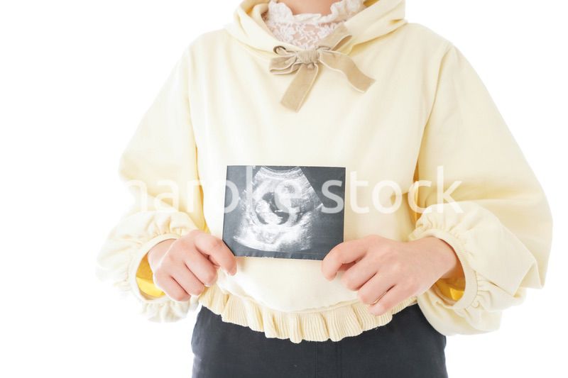 エコー画像を持つ若い妊婦の女性