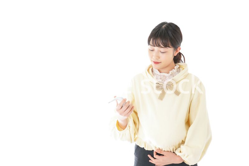 検温をする若い妊婦の女性