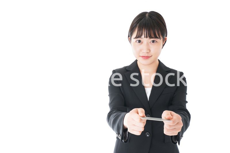 名刺交換をするスーツを着たビジネスウーマン