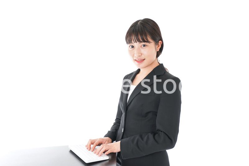 立ってデスクワークをする若いビジネスウーマン