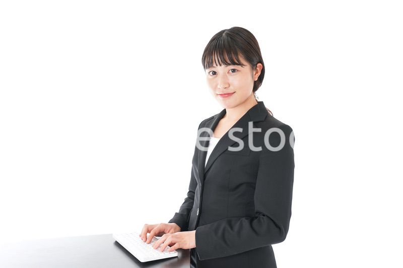 立ってデスクワークをする若いビジネスウーマン